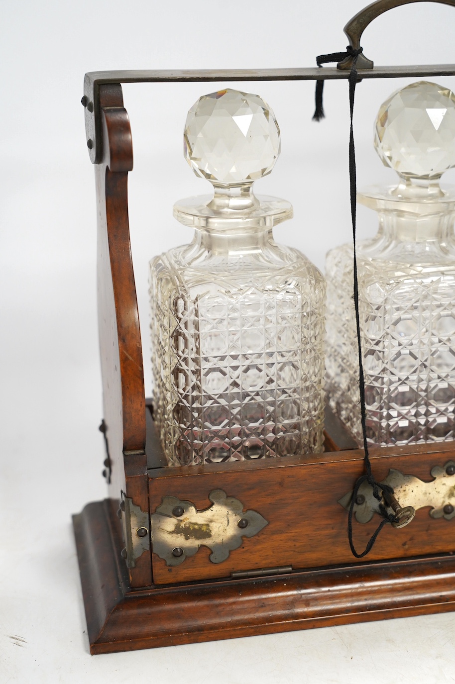 A three bottle tantalus with key, 38cm wide. Condition - fair, chipping to the stoppers